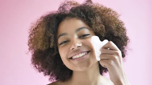 Woman Massaging Face with a Beauty Tool