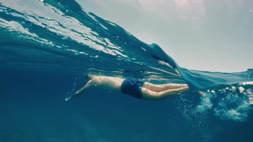 Boy Swims in the Ocean Water