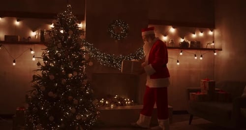 Santa Placing Gift Under Christmas Tree At Home