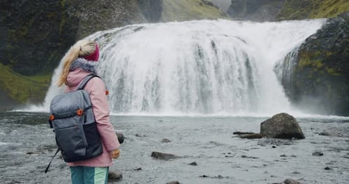 Iceland Woman with Backpack Enjoying Stjornarfoss Waterfall Near Kirkjubaejarklaustur