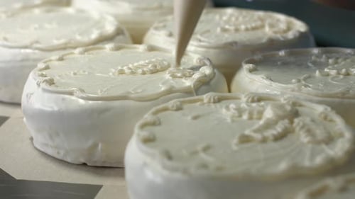 Decorating Cakes with White Frosting and Chocolate Pieces