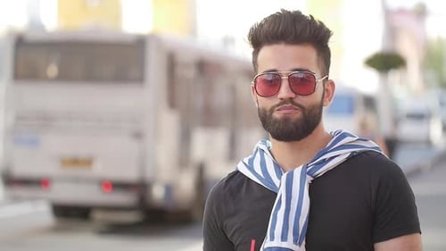 Concept of Street Food and City Life. Young Smiling Bearded Man Holding a Cup with Drink Juice