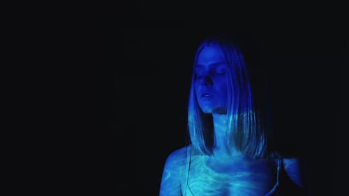 Woman bathed in abstract blue neon light