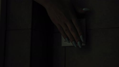 Jovem mulher de eletricidade acende a luz em ambientes fechados com interruptor na parede