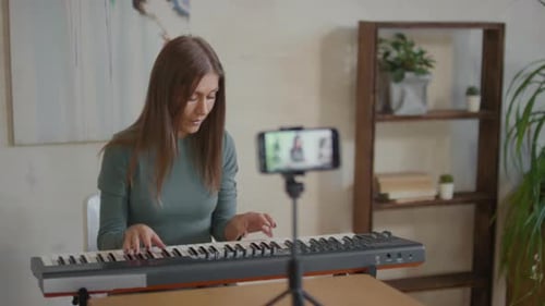 Woman Plays Piano During Online Music Lesson