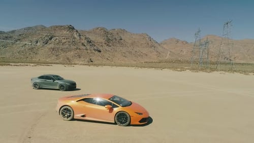 Aerial View Two Exotic Sports Cars in the Middle of Dry Desert with Mountain USA