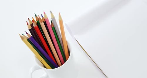 Colorful Pencils in a White Mug on a Desk
