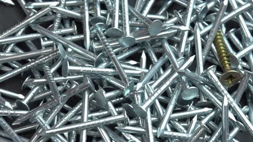 Close Up of Silver Nails and Yellow Screw