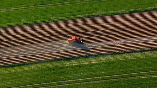Aerial View of Tractor Performs Seeding on the Field