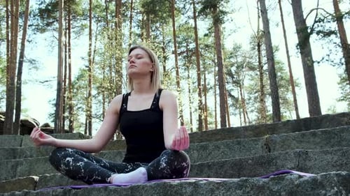Woman Meditating in Nature on Stone Steps