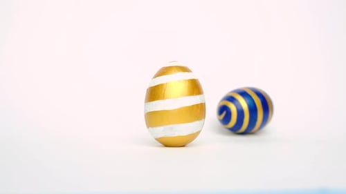 Easter Eggs are Rolling Knocking Each Other on White Table