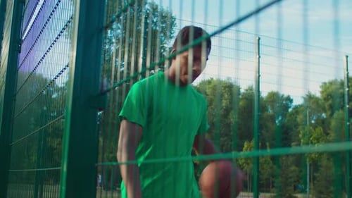 Skillful Streetball Player Dribbling Ball on Court