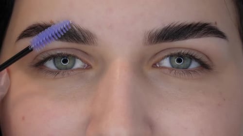 Woman Styling Eyebrows with Brush in Close-Up