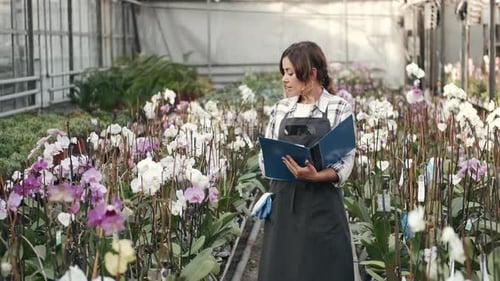 Ouvrier d'usine en uniforme contrôlant les orchidées
