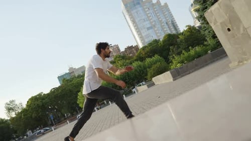 Athletic Man Jump Somersaults in an Urban Setting Backdrop Beautiful Building