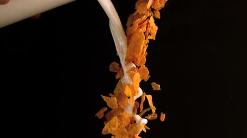Milk mixed with cereals pouring