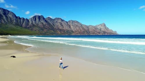 Aerial of woman walking on beautiful beach 4k