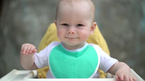 Smiling Baby Sitting in High Chair