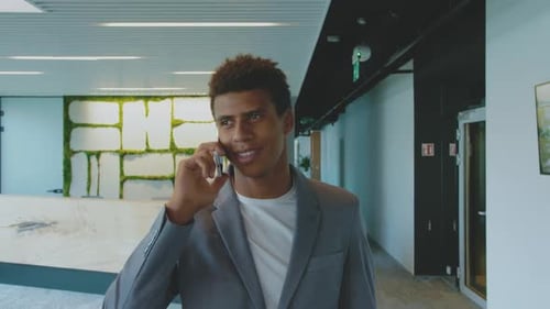 Young Adult Talking on Phone in Modern Office