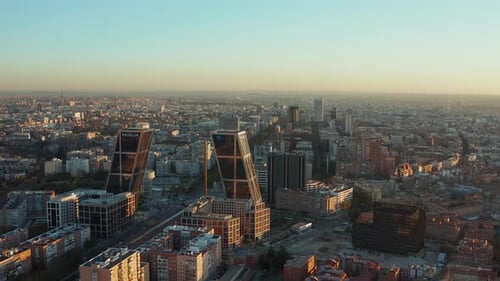 Forwards Fly Above Business District of City in Evening Sunlight