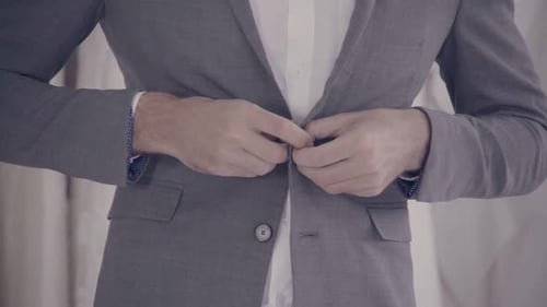 Man in Formal Suit Getting Dressed in Dressing Room for Work or Wedding