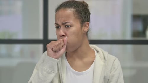 Young Adult Woman Coughing Indoors