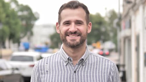 Smiling Man Standing on Urban Street