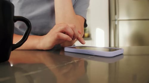 Adult Using a Smartphone in a Bright Kitchen