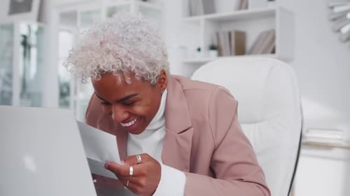 Woman Celebrating Good News in Office Reading Paperwork