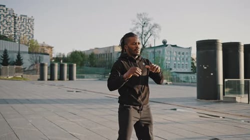 Active African American Man Warming Up His Body Preparing for Run Workout at Urban Area Tracking