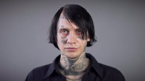 Man with Tattoos on Face and Neck