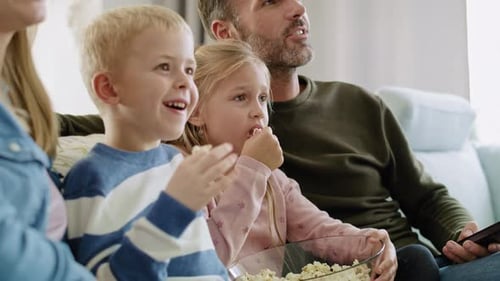 Happy Family Watching TV and Eating Popcorn