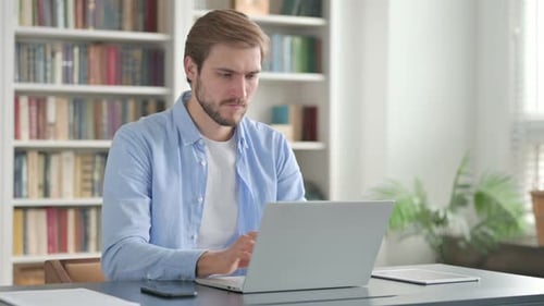 Man Closing Laptop and Leaving Office