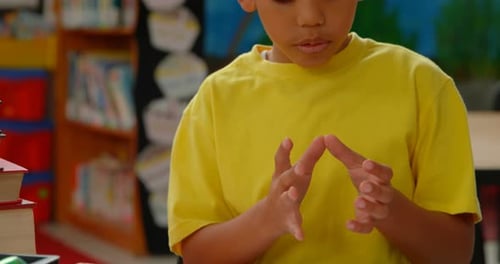 Front view of African American schoolboy counting with his finger at desk in a classroom at school 4