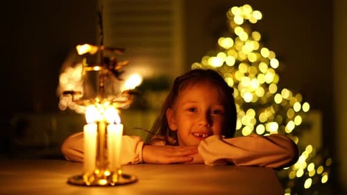 Smiling Girl by Candles at Christmas Time
