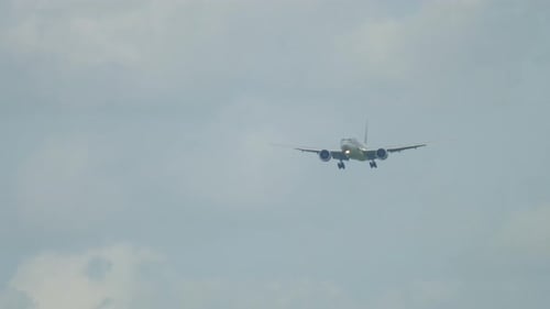Airplane flying in the cloudy sky