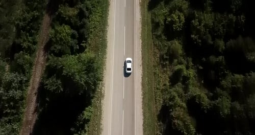 Luftaufnahme über Waldstraße mit Autos fliegen