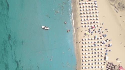 Top View of Sand Beach with Umbrellas Boat and Swimming People in Sea Bay Water