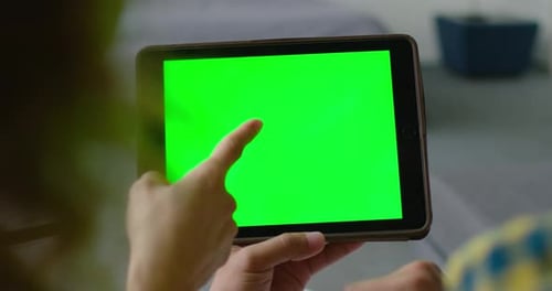 Woman and Man Use a Tablet Computer with a Green Screen To Make a Purchase