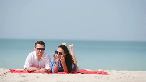 Young Family of Two on White Beach During Summer Vacation