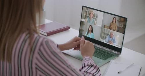 Back View of Female Employee Speak Talk on Video Call with Diverse Multiracial Colleagues on Online