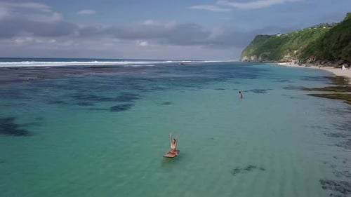 Woman Relaxing in the Sea on a Surfboard