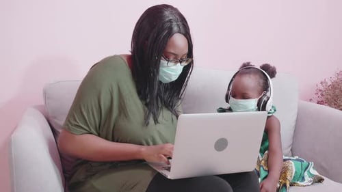 Parent and Child Using Laptop Computer at Home