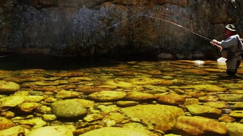 Fisherman fly fishing in river