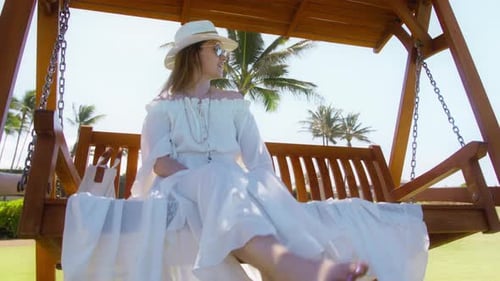 Woman Relaxing on a Swing in a Tropical Setting
