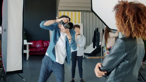 Slow Motion of Male Photographer Working with Model in Studio Taking Photos