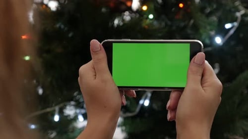 Christmas tree lights and female with green screen gadget 4K 2160p 30fps UltraHD footage - Woman h