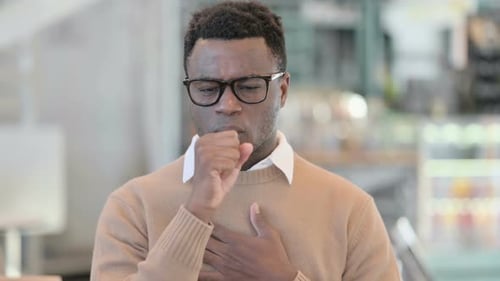 Young Adult Coughing in an Office Environment