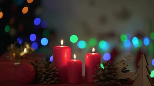 Burning Candles with Christmas Decorations and Glowing Lights