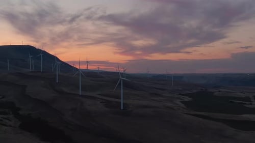 Beautiful Aerial Landscape View of Wind Turbines on a Windy Hill during a colorful sunrise. Taken in